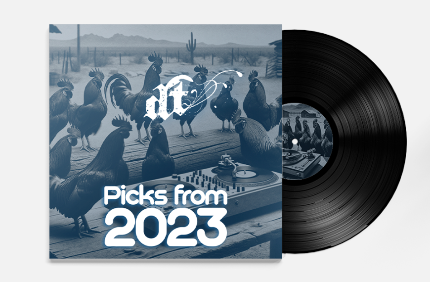 This image shows a vinyl record album cover for "Picks from 2023" by "nit." The cover features a surreal blue-tinted scene with several roosters and chickens gathered around a DJ turntable setup in what appears to be a desert landscape with cacti and mountains in the background. The "nit" logo appears at the top in white stylized text, while "Picks from 2023" is prominently displayed in large white letters at the bottom. A black vinyl record is partially visible extending from behind the album cover, and there appears to be a matching label on the record itself.