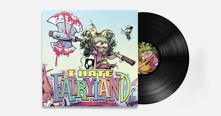 A vinyl record with colorful comic-book cover art for “I Hate Fairyland.” The cover shows the green-haired character Gertrude (Gert) in pigtails, grinning and brandishing a large, blood-splattered double-headed axe. Hey tiny winged sidekick hovers nearby. The bold, multicolored title “I HATE FAIRYLAND” spans the bottom. The black LP is partially slid out to the right, with a label image of Gert.